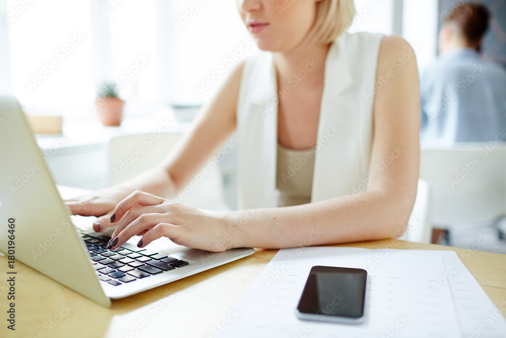 Young analyst entering data about her company and its news in the net Young analyst entering data about her company and its news in the net