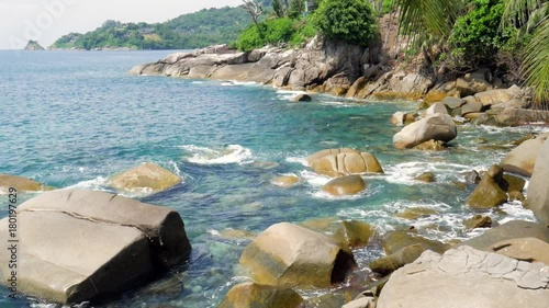 Stones at the coast in the sea. A view to the sea and big stones at the tropical shore in a sunny day.