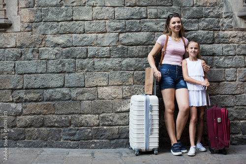 mother and daughter with travelling bag