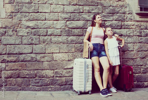 mother and daughter with travelling bag