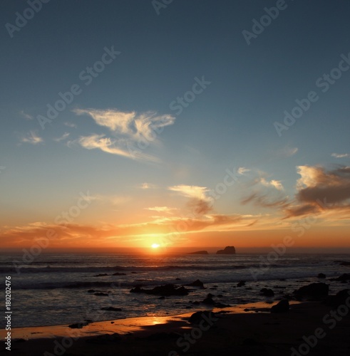  sun goes down the skyline on the ocean with small island silhouette