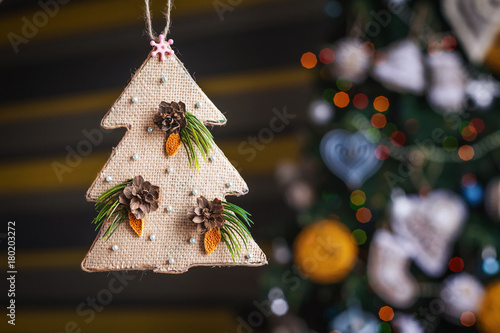 Christmas sackcloth tree. xmas decorations with toys, sparkling, glowing. Happy New Year and Xmas theme . handmade decor