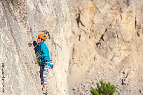 The girl climbs the rock.