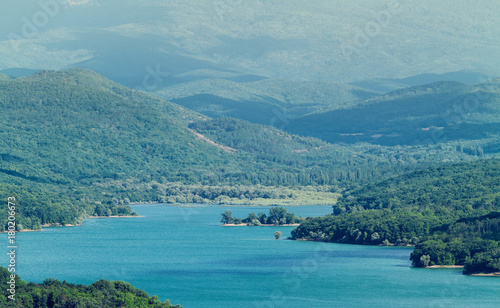 High mountains covered with forests over the lake
