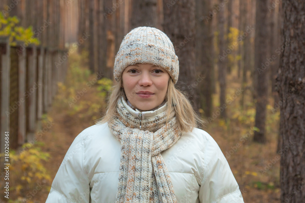 Portrait of a young pretty woman in winter clothes on a background of autumnal scenery Portrait of a young pretty woman in winter clothes on a background of autumnal scenery