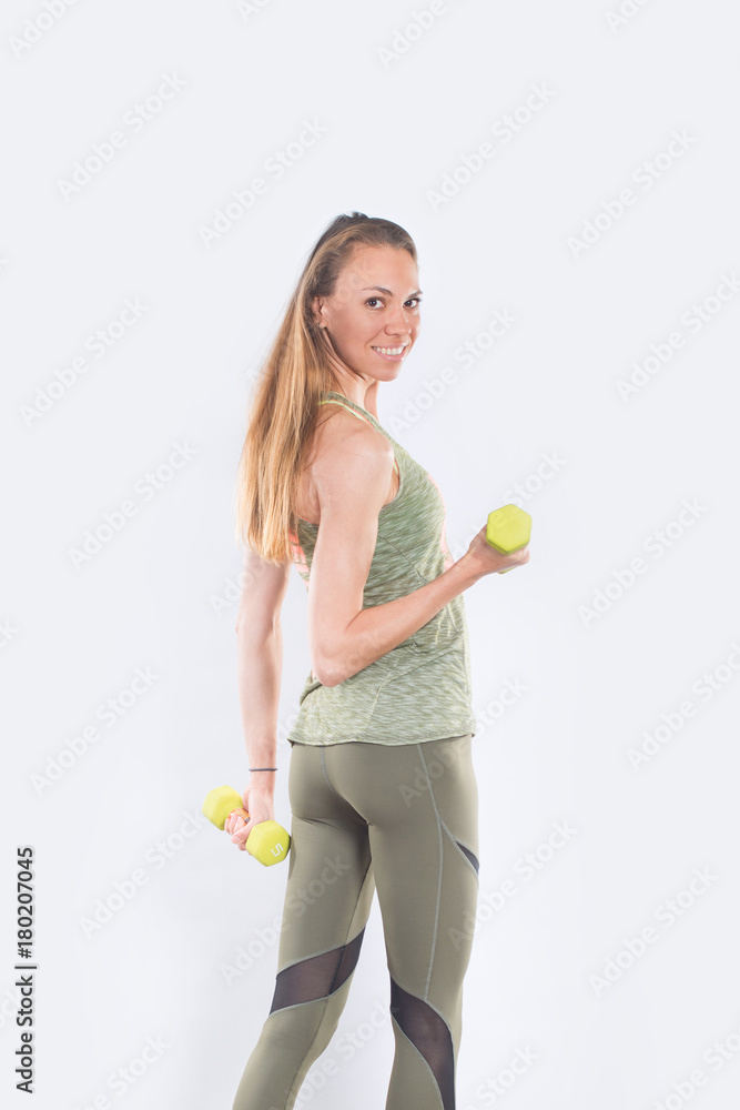 Young positive smiling woman working out with weights Young positive smiling woman working out with weights