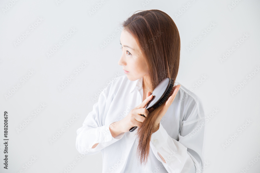 髪をくしでとかす女性
髪をくしでとかす女性