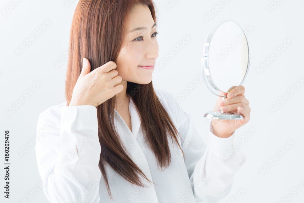 鏡で髪をチェックする女性
