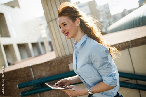 Portrait of businesswoman walking and holding tablet