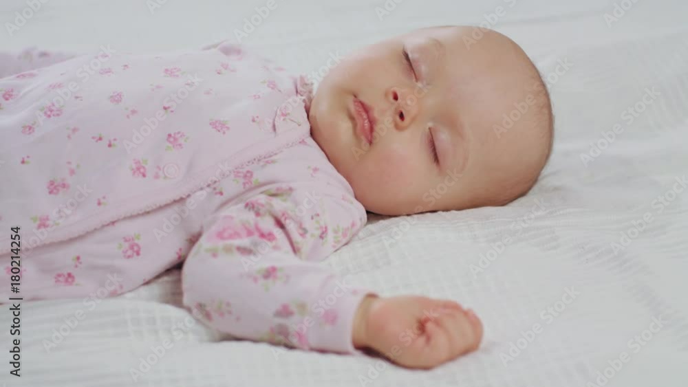 A baby sleeping sound on a white bed at home. Medium dolly shot. A baby sleeping sound on a white bed at home. Medium dolly shot.