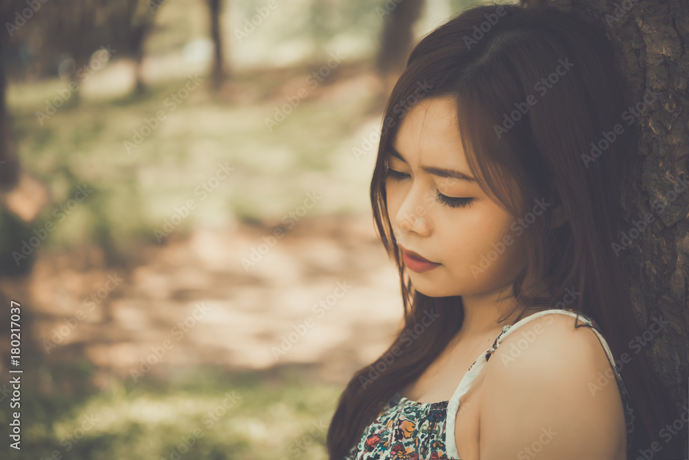 Close up asian sad woman sit on the tree ,heartbreak girl concept Close up asian sad woman sit on the tree ,heartbreak girl concept