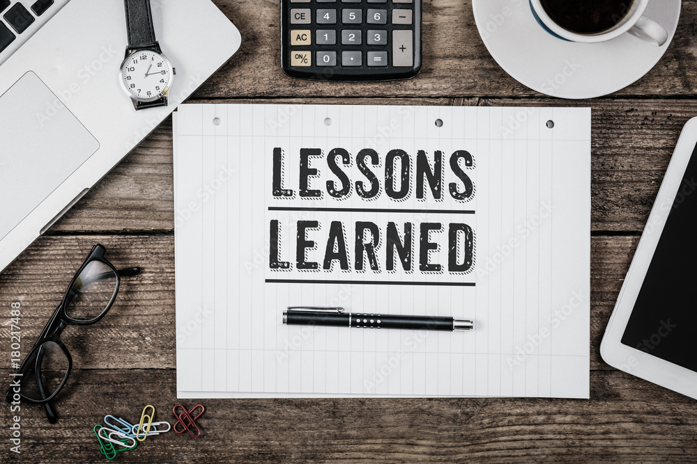 Lessons learned statement on notepad on office desk from above