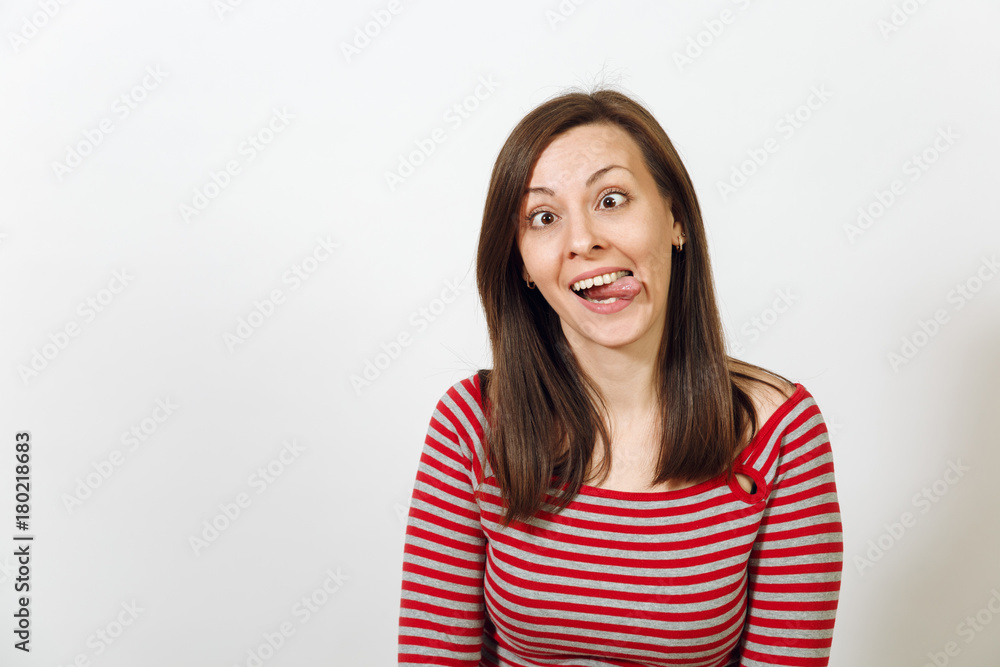 Beautiful European young happy brown-haired woman with healthy clean skin, dressed in casual red and grey clothes, fooling and showing the tongue on a white background. Emotions concept. Beautiful European young happy brown-haired woman with healthy clean skin, dressed in casual red and grey clothes, fooling and showing the tongue on a white background. Emotions concept.
