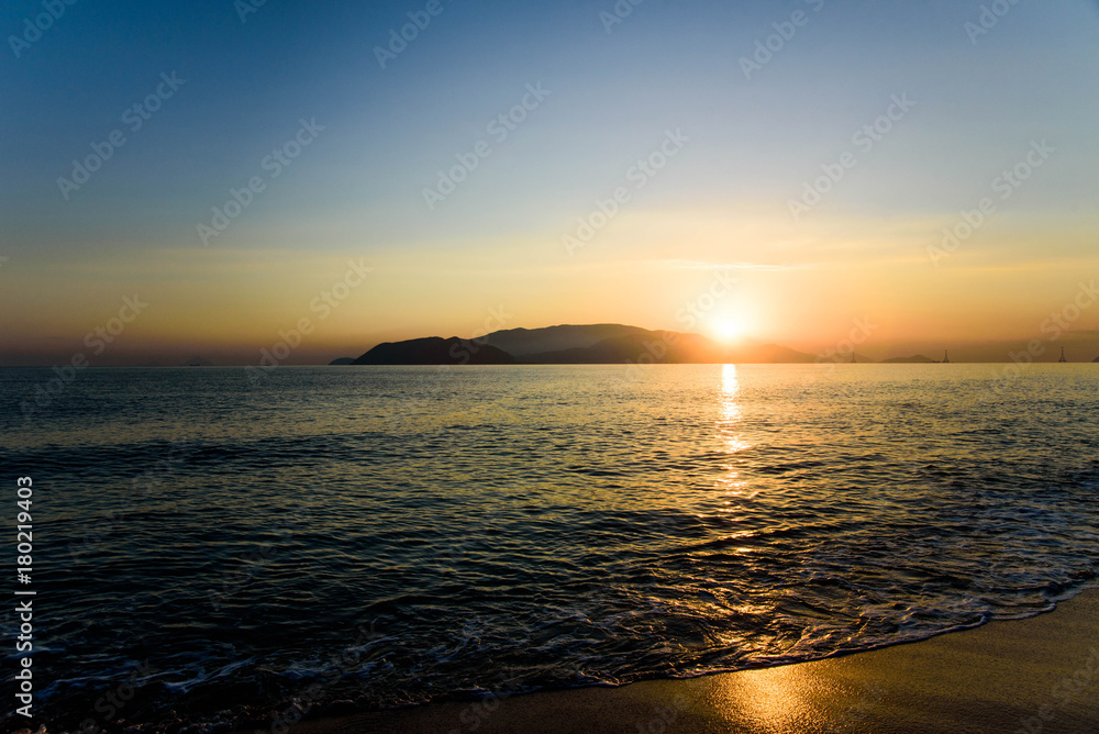 Fototapeta premium Colorful sunrise over sea and the beach with clear skies in Vietnam