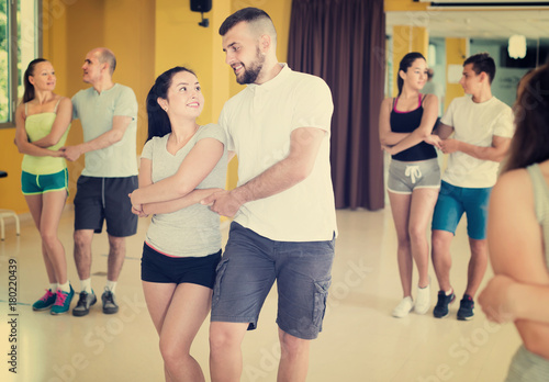 Enthusiastic dancing couples learning salsa