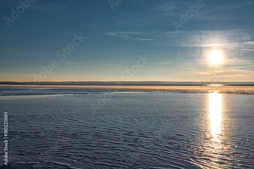 reflection of the evening sun from the first ice on a cold decline at the beginning of winter