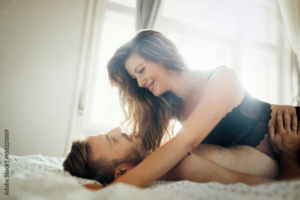 Attractive couple sharing intimate moments in bedroom Attractive couple sharing intimate moments in bedroom