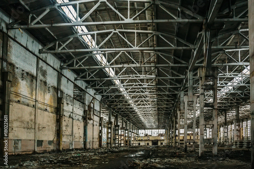 Abandoned large industrial hall or warehouse with garbage, manufactory factory