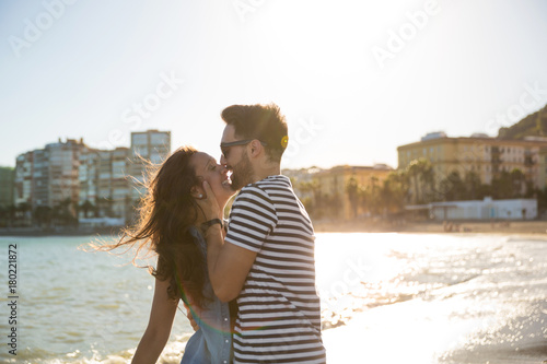 Young man kissing his girlfriend smiling