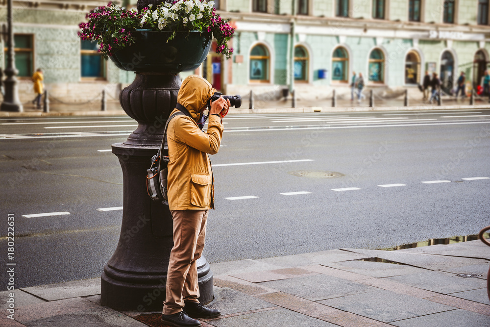 Photographer taking a shot by his camera on street. Travel photography concept