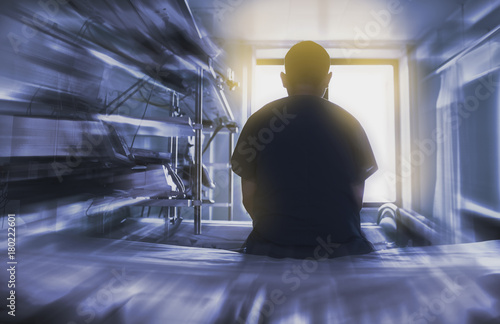 Fotografie Man sitting on the hospital bed looking through the window, concept of dying pat