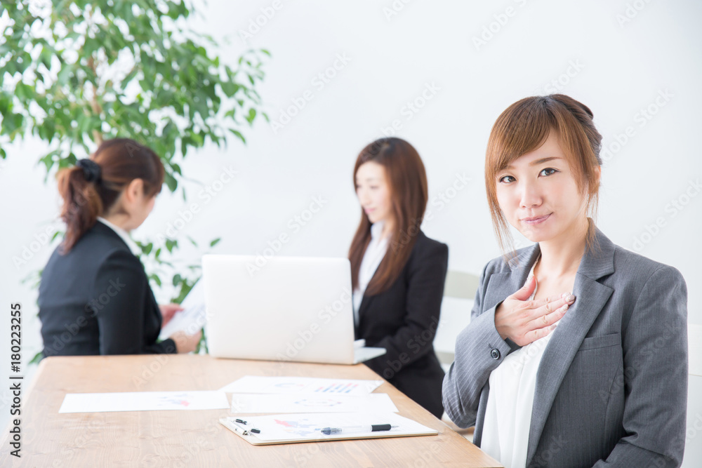 胸に手をあてるビジネスウーマン