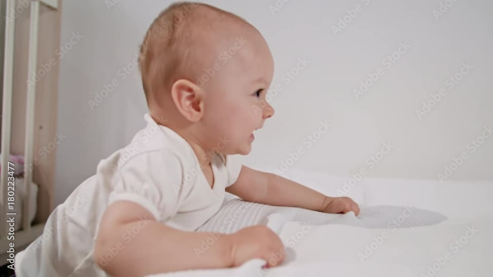 Baby's standing near the bed at home and playing. Medium shot. Baby's standing near the bed at home and playing. Medium shot.