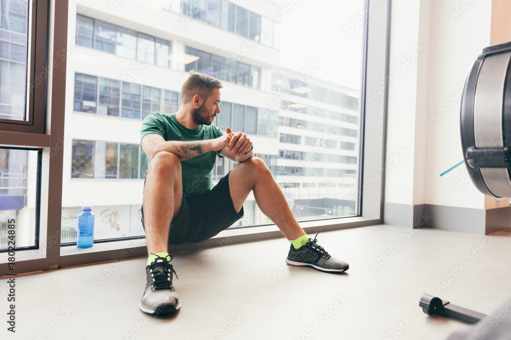 Fototapeta premium Young man having a break in his gym workout.