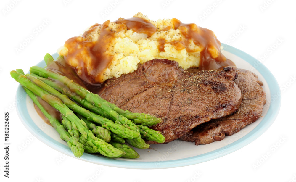 Fried venison steak meal with mashed potatoes and asparagus isolated on a white background Fried venison steak meal with mashed potatoes and asparagus isolated on a white background