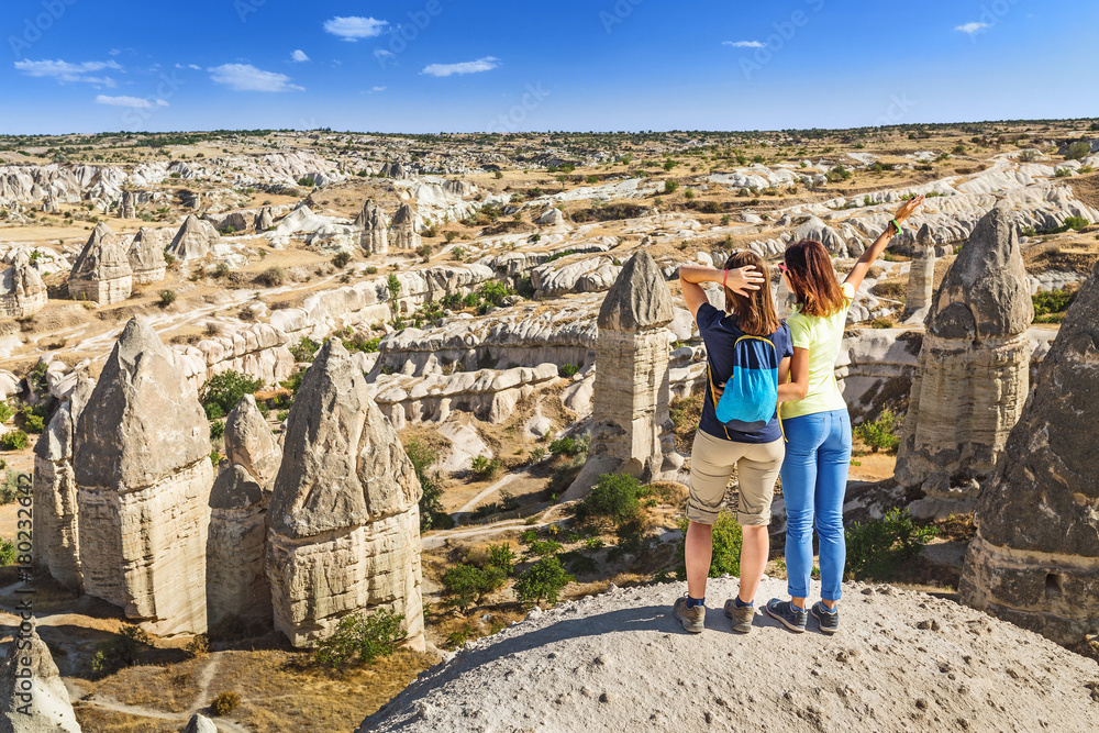 Group of Friends travelling among Cappadocia fairy chimneys at summer
