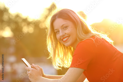 Happy girl with smart phone at sunset