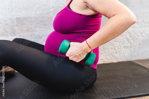 Pregnant woman exercising during pregnancy in her home. 