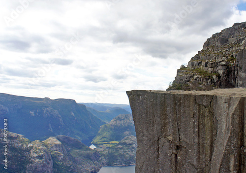Edge of Preikestolen cliff (Prekestolen or Pulpit Rock) at fjord Lysefjord, famous and popular travel destination in Forsand, Norway. Beautiful landscape of norwegian nature, sunny day.