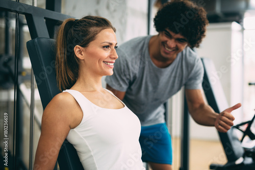 Young beautiful woman doing exercises with personal trainer