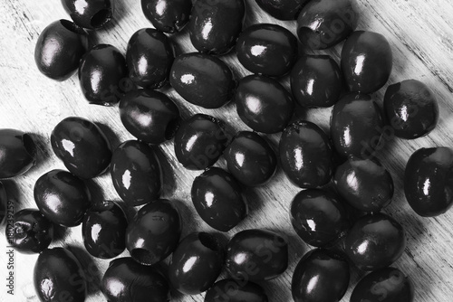 Black olives on a white wooden background closeup © jalisko