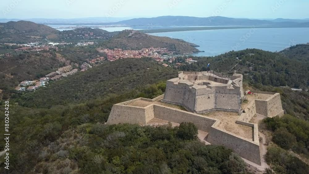 A huge castle on top of the hill in Monte Argentario with the view of the small houses on the other side of the county A huge castle on top of the hill in Monte Argentario with the view of the small houses on the other side of the county