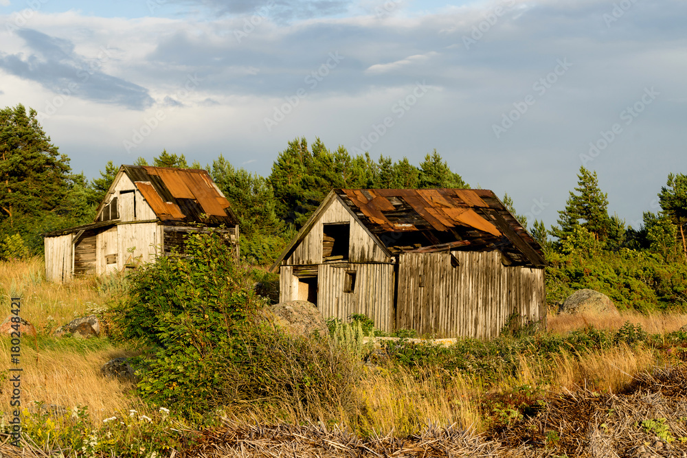 Fototapeta premium Abandoned houses in the Baltic Sea. Shore, nature and ruins facilities architecture concept. Mohni, small island in Estonia, Europe.