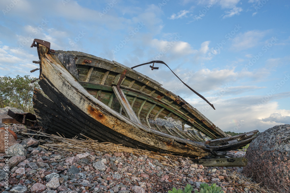 Old boat, shore, evening light, sunset, clouds and architecture concept in the Baltic Sea. Mohni, small island in Estonia, Europe. Old boat, shore, evening light, sunset, clouds and architecture concept in the Baltic Sea. Mohni, small island in Estonia, Europe.
