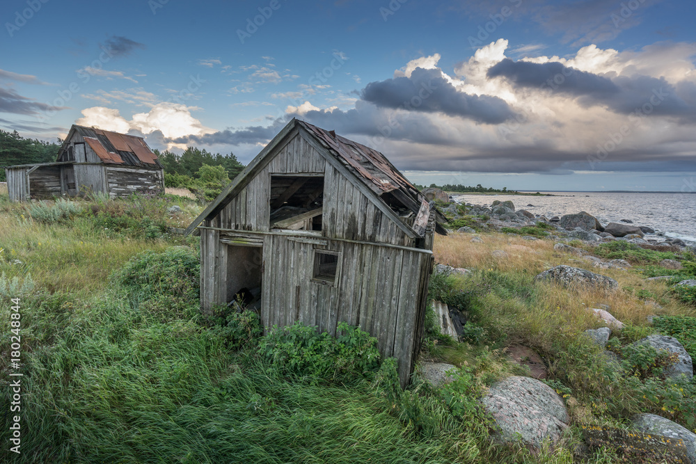 Obraz premium Abandoned houses in the Baltic Sea. Shore, nature and ruins facilities architecture concept. Mohni, small island in Estonia, Europe.