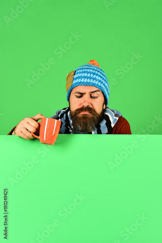 Hipster with beard and confused face looks down