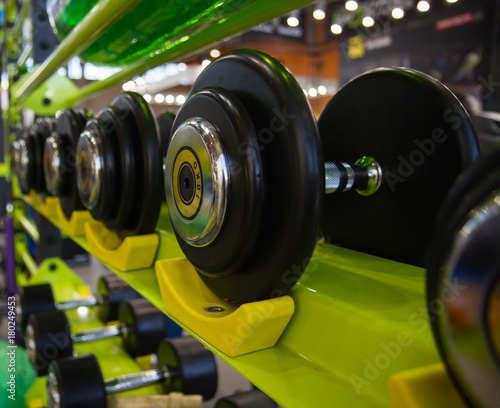 Fototapeta Naklejka Na Ścianę i Meble -  Dumbbells in gym, close up many on rack in sport fitness centre.
