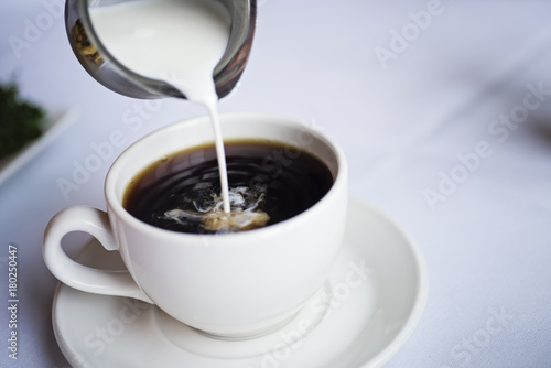 Canvastavla Pouring creamer into a cup of coffee