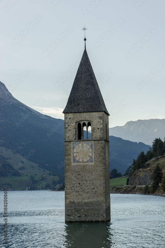 Church under water, drowned village, mountains landscape and peaks in background. Reschensee Lake Reschen Lago di Resia. Italy, Europe, Südtirol, South Tyrol, Upper Adige, Alto Adige