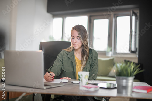 Young woman working at home on computer