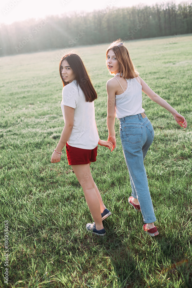 Two beautiful girls walking in nature. Back view