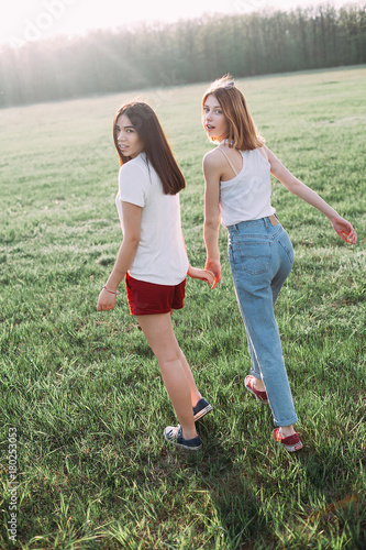 Two beautiful girls walking in nature. Back view