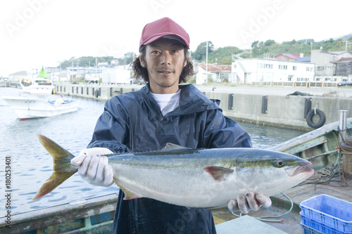 Portrait of fisherman holding fish photo