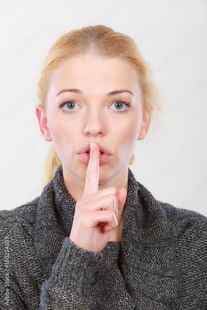 Woman holding finger close to lips, silence Woman holding finger close to lips, silence