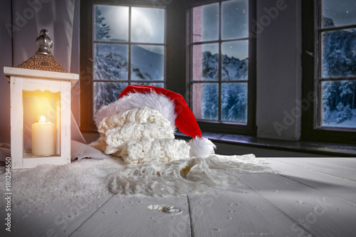 Wooden table of free space for your decoration. Window with view of mountains and moon at night. Christmas time decoration.