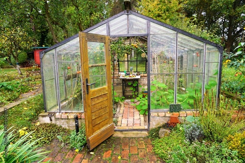 Greenhouse with bricks and tomatoes in a garden